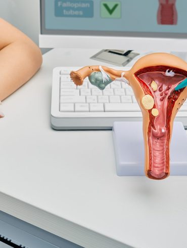 A nurse and doctor discuss endometriosis symptoms by using a physical model of the uterus